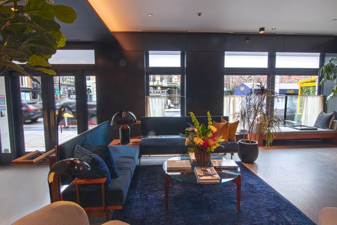 The Frederick Hotel's lobby lounge — deep blue velvet sofas, brass lamps and tall windows onto West Broadway.