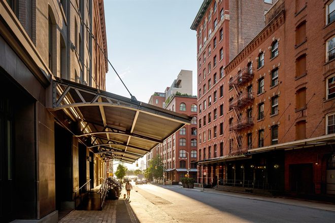 The Smyth Tribeca's awning over the pavement on a quiet Tribeca street at golden hour, cast-iron and red-brick facades beyond.